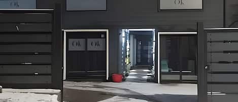 Entrada de un edificio con dos puertas que dicen 'OK' y un camino que lleva al interior.