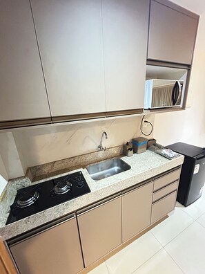 Een keuken met een gasfornuis, een spoelbak en kastjes.