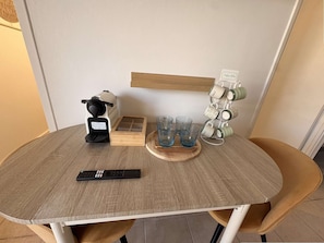 A dining table with a coffee maker, a remote control, and a mug rack. - Renovated Studio with Balcony 2/4 guests– Central Arcachon (ARCACHON)