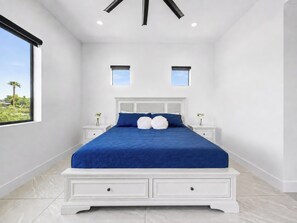 A bedroom with a large bed, two bedside tables, a window with a view, and a ceiling with recessed lighting. - Valencia - 35' Ceilings - Private Pool - Biltmore (Phoenix)