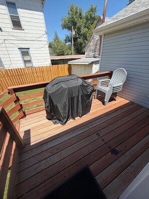 A wooden deck with a covered grill, a white plastic chair, and a wooden fence. - 5 Minute Walk to Kendrick Park and Main Street - Peace in the Middle of Town! (Sheridan)