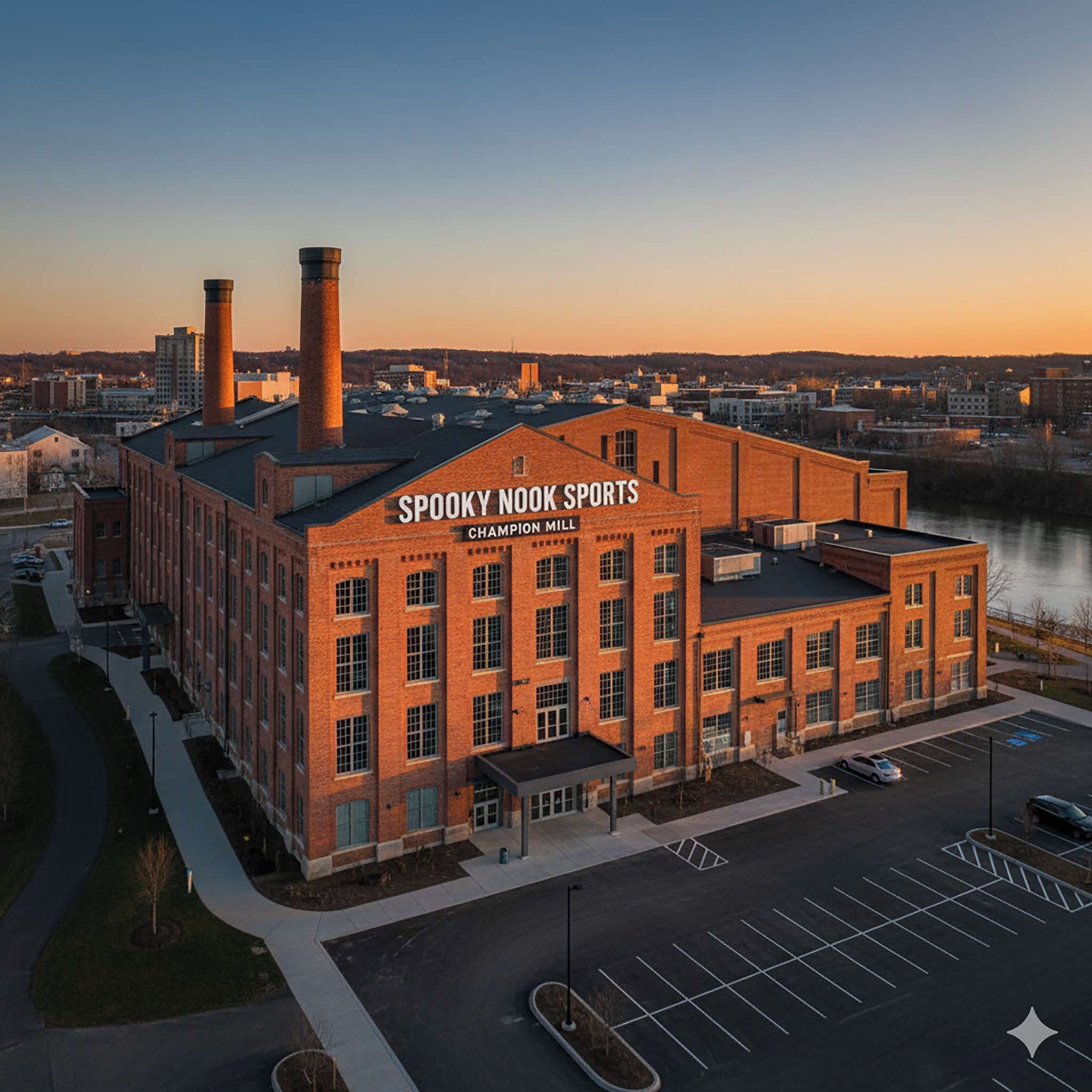 A brick building with the sign "Spooky Nook Sports Champion Mill" at sunset.