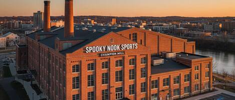 Un edificio de ladrillo con el letrero "Spooky Nook Sports Champion Mill" al atardecer.