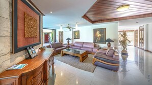 Eine geräumige Lobby mit einer Rezeption, Ledersofas, einem Couchtisch und einer Buddha-Statue.