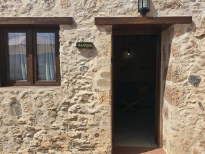 Ein Steinhaus mit einem Schild, auf dem 'AGANDA' über einem Eingang steht.