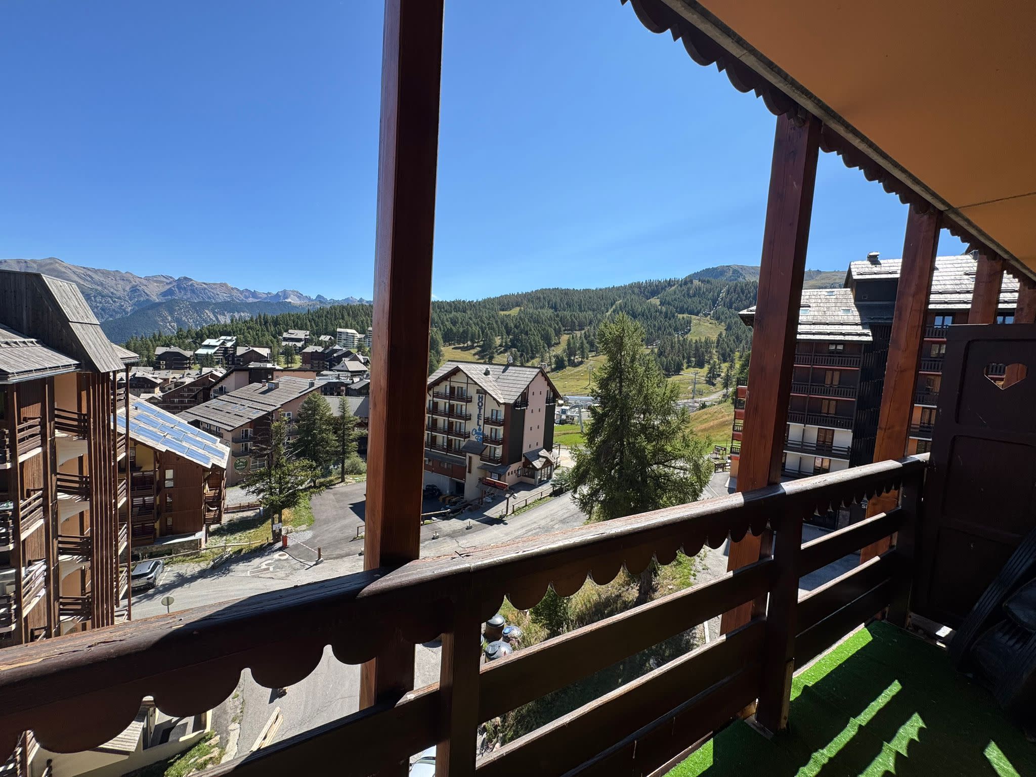 A balcony with a view of a town and mountains.