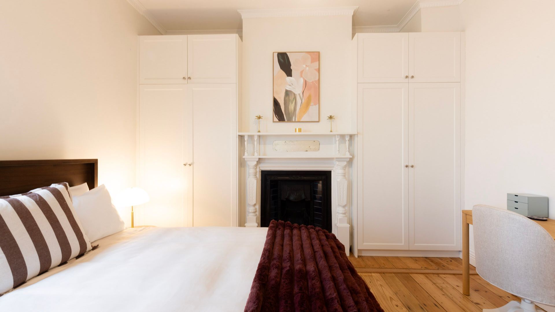 A hotel room with a bed, a fireplace, and a desk.