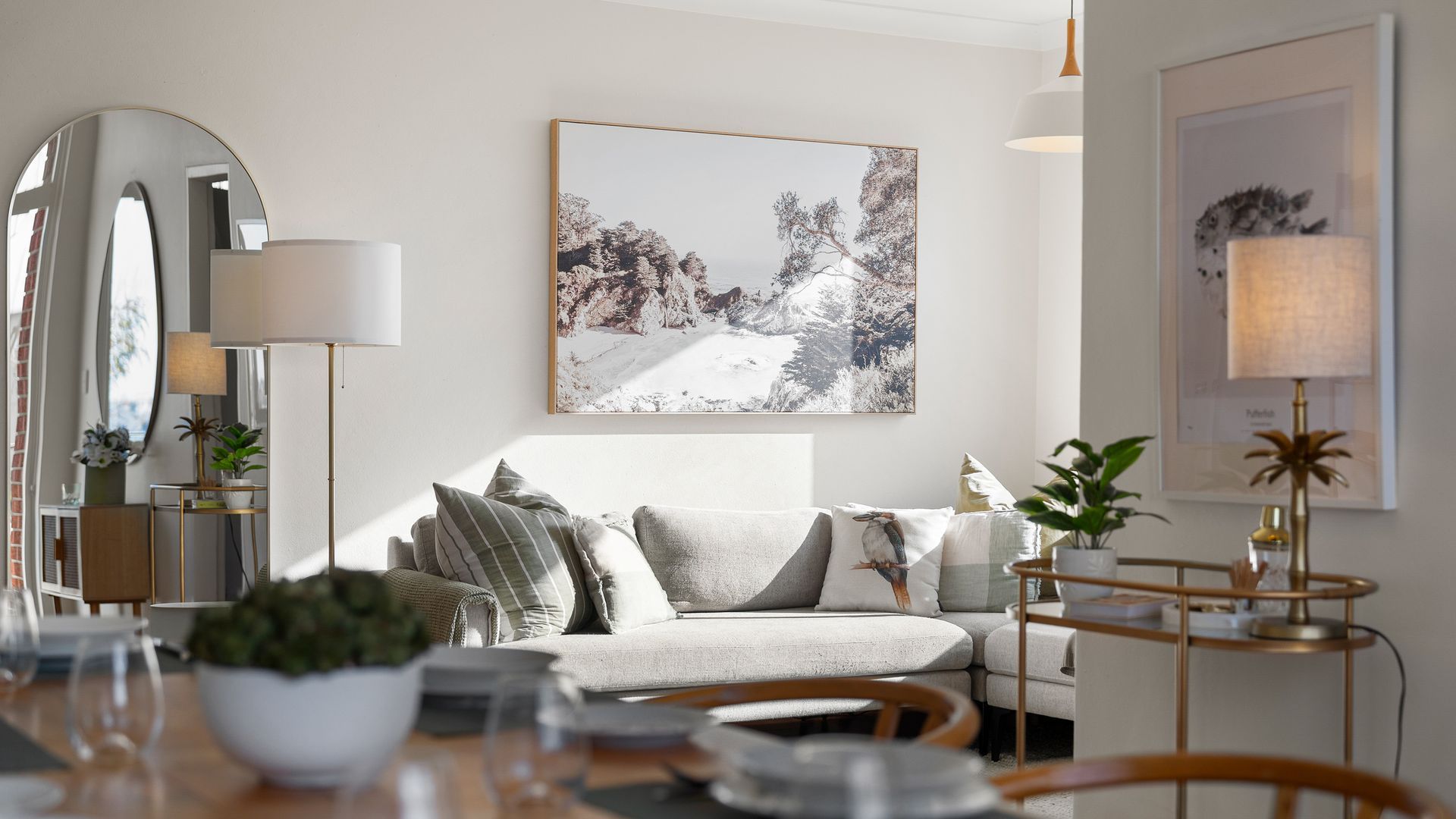 A modern living room with a sofa, a coffee table, and a dining area with chairs and a table.
