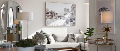 A modern living room with a sofa, a coffee table, and a dining area with chairs and a table.