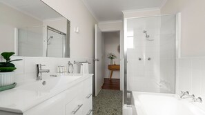 A modern bathroom with a double sink, a shower, and a large mirror. - The Birdsnest Bondi (Waverley)