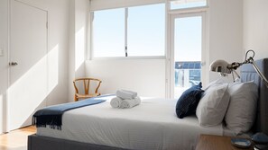 A bedroom with a bed, a chair, a desk, and a window. - The Birdsnest Bondi (Waverley)