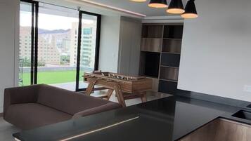 A modern kitchen with a central island, wooden cabinetry, and a built-in stove.