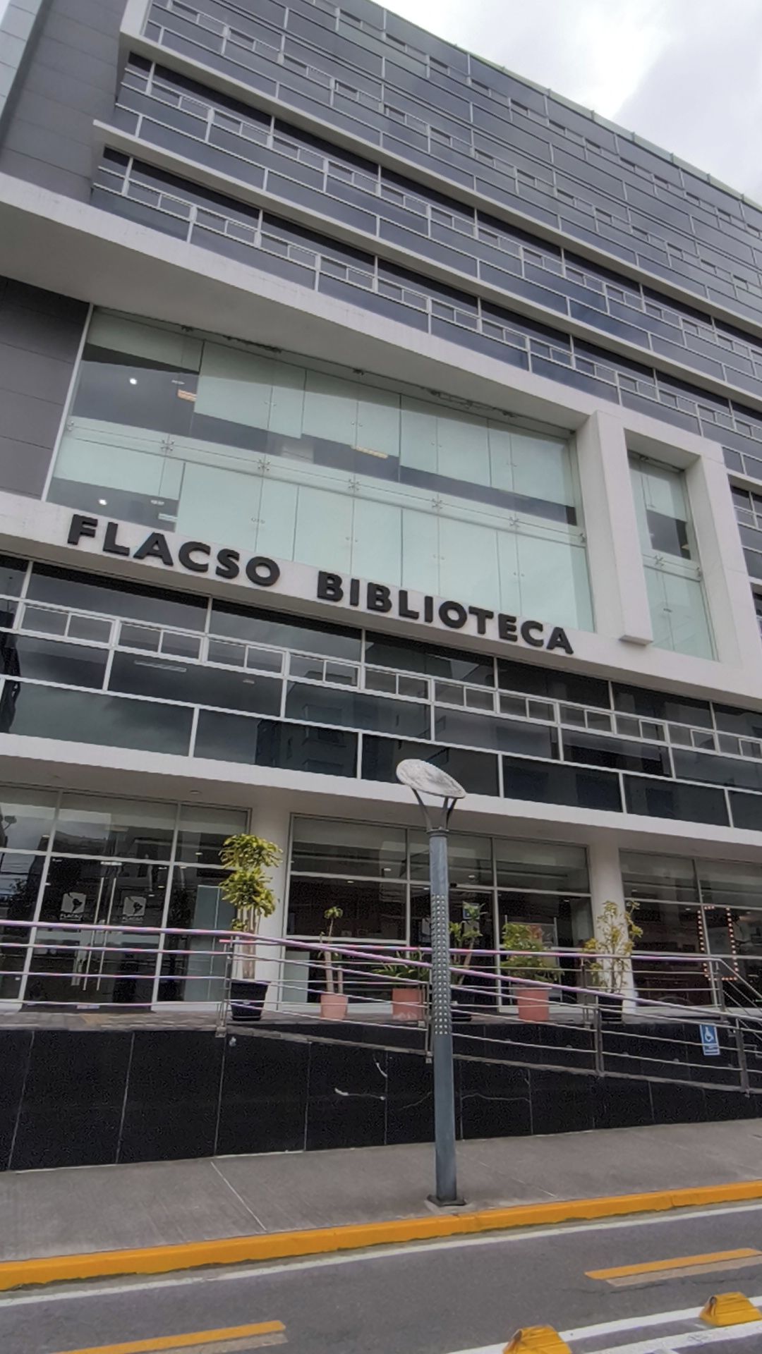 En moderne bygning med skiltet 'FLACSO BIBLIOTECA', der angiver, at det er et bibliotek.