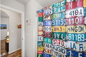 A wall covered with various license plates. - Experience Route 66! Stay in this unique 3BR themed home featuring Chicago, Springfield, & Los Angeles-inspired bedrooms and a Tulsa-themed living room, a fenced yard, and private patio. (Broken Arrow)