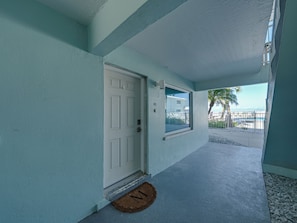 A corridor with a white door, a window, and a doormat. - BG Beach Club 3B - 2 bed / 2 bath / Close to VIllage / Sleeps 6 / No Stairs! (Boca Grande)