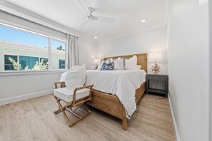 A bedroom with a bed, a chair, a nightstand, and a window. - BG Beach Club 3B - 2 bed / 2 bath / Close to VIllage / Sleeps 6 / No Stairs! (Boca Grande)
