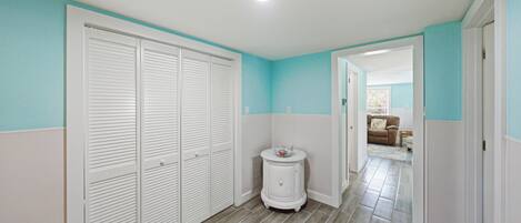 A hallway with a white door, a white cabinet, and a blue wall.