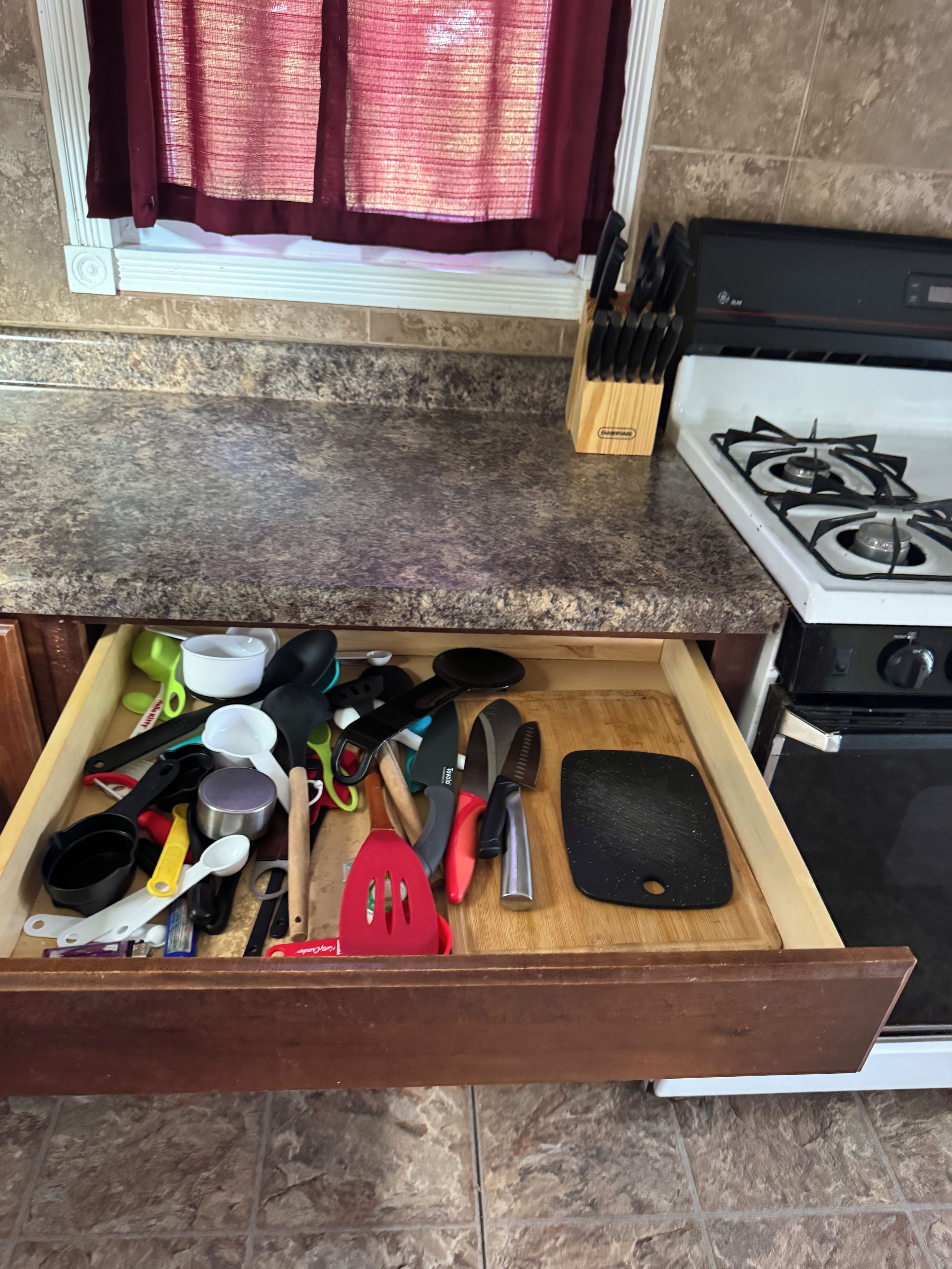 Un cajón de cocina con diferentes utensilios y utensilios de cocina.