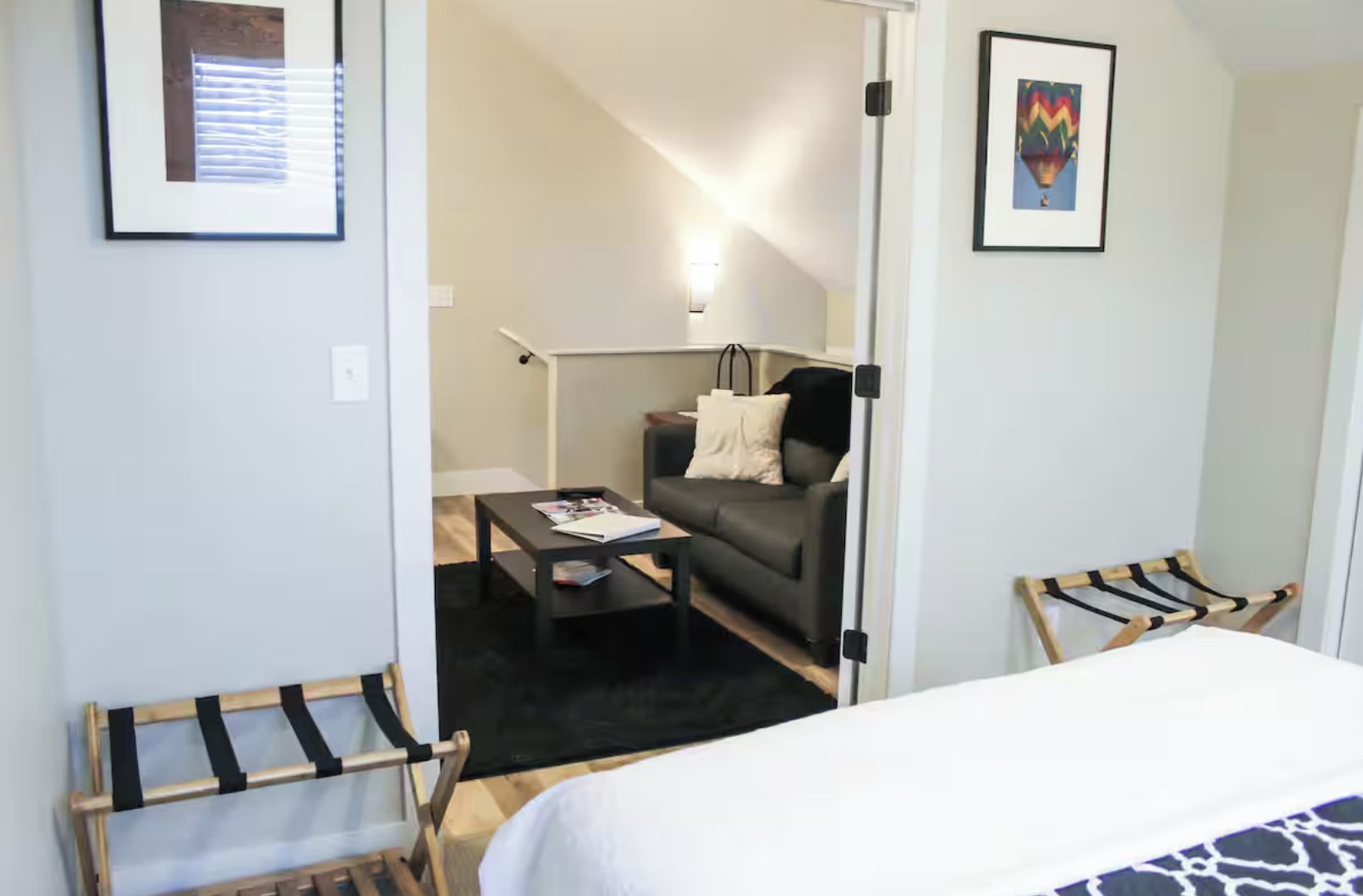 Une chambre d’hôtel avec un lit, un canapé, une table basse et deux fauteuils.