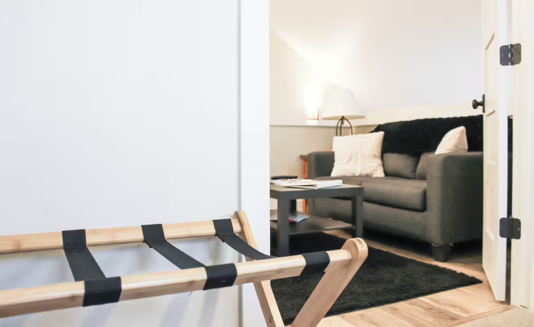 Et værelse med en seng, en sofa, et sofabord og en lampe.
