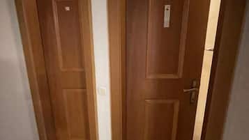 A hallway with two wooden doors, one of which is slightly ajar.