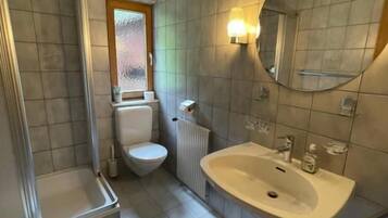 A bathroom with a toilet, sink, and shower.