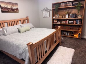A bedroom with a wooden bed, a bookshelf, and a framed quote on the wall. - The Gathering Place (Idaho Falls)