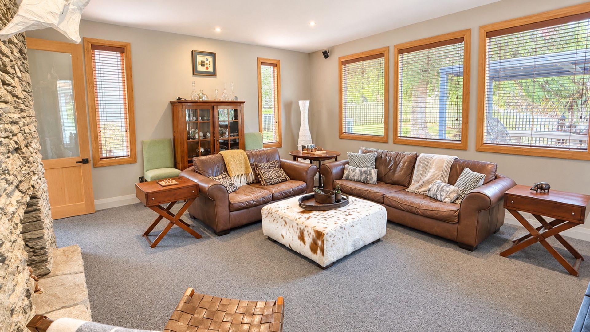 A living room with a sectional sofa, a coffee table, and a cabinet.