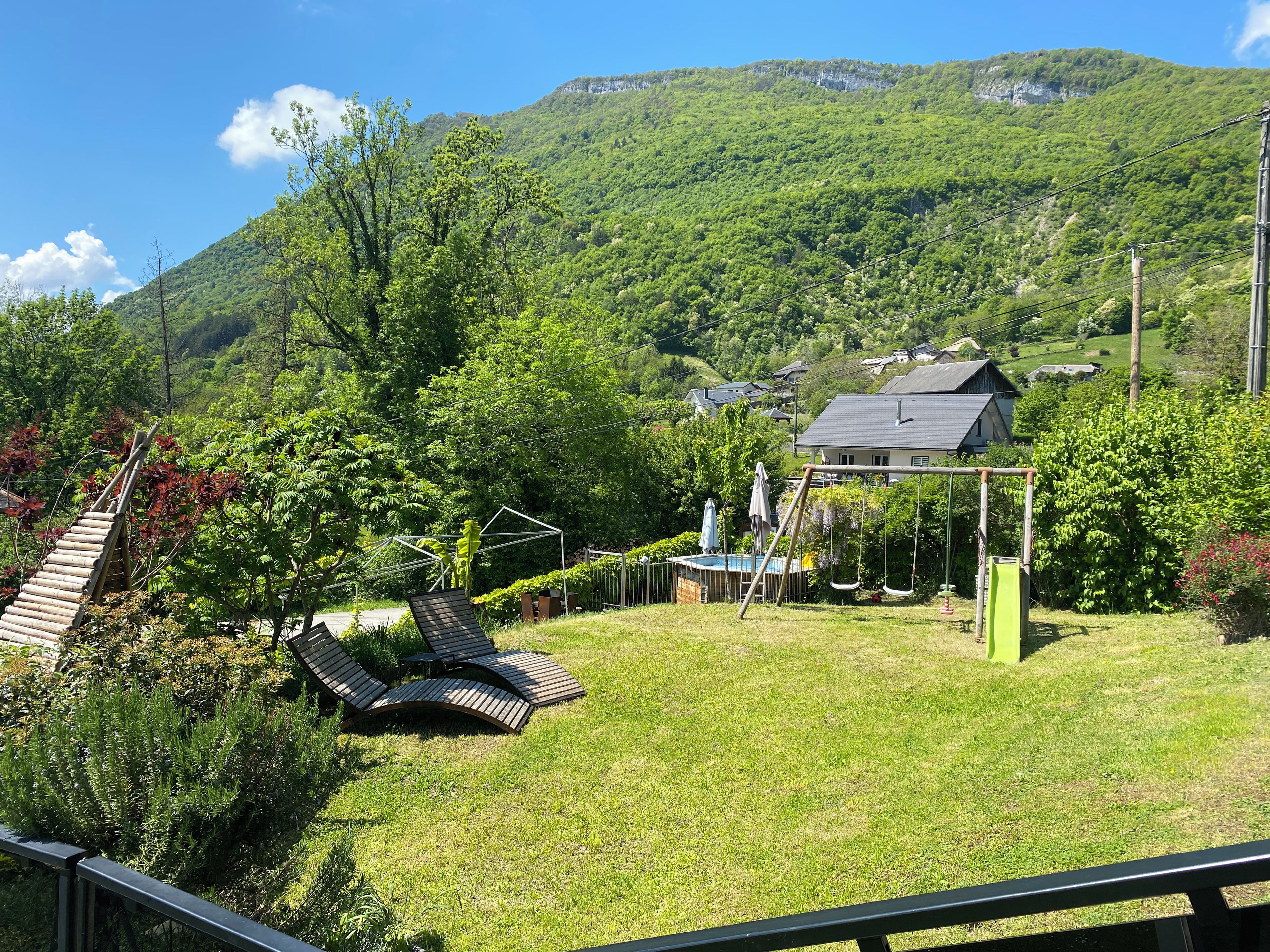 Ein Wohngebiet mit einem Haus, einer Schaukel und einem Schwimmbad.