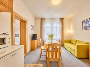 A compact living space with a kitchenette, a dining area, and a sofa. - Cosy apartment for 3 people with WIFI, TV, patio and pets allowed (Trutnov)
