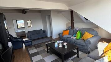 A modern living room with a sofa set, a coffee table, and a television.