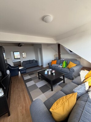 Una sala moderna con un sofá, una mesa de centro y un televisor.