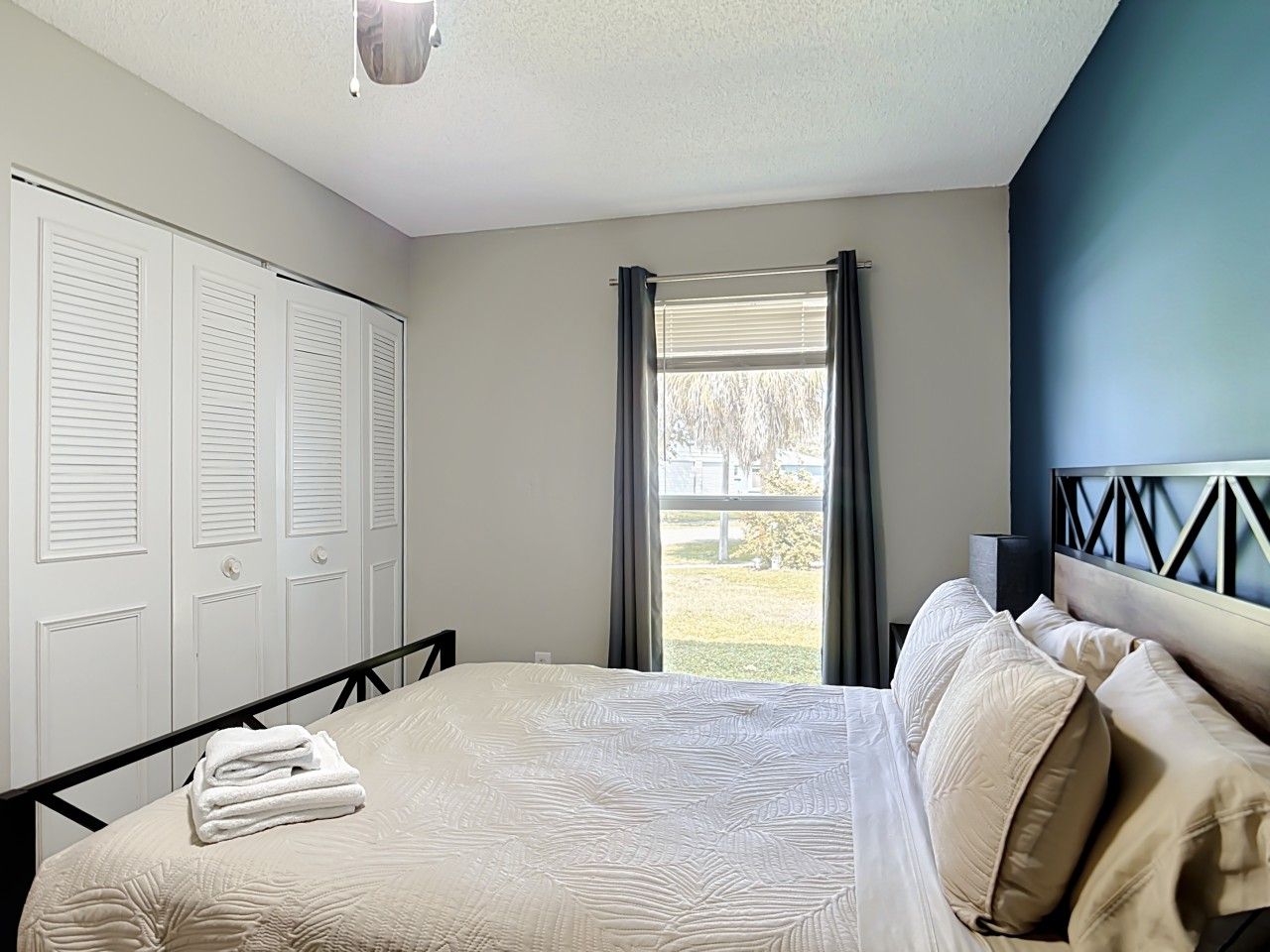 Une chambre à coucher avec un lit, une armoire et une vue sur l’extérieur.