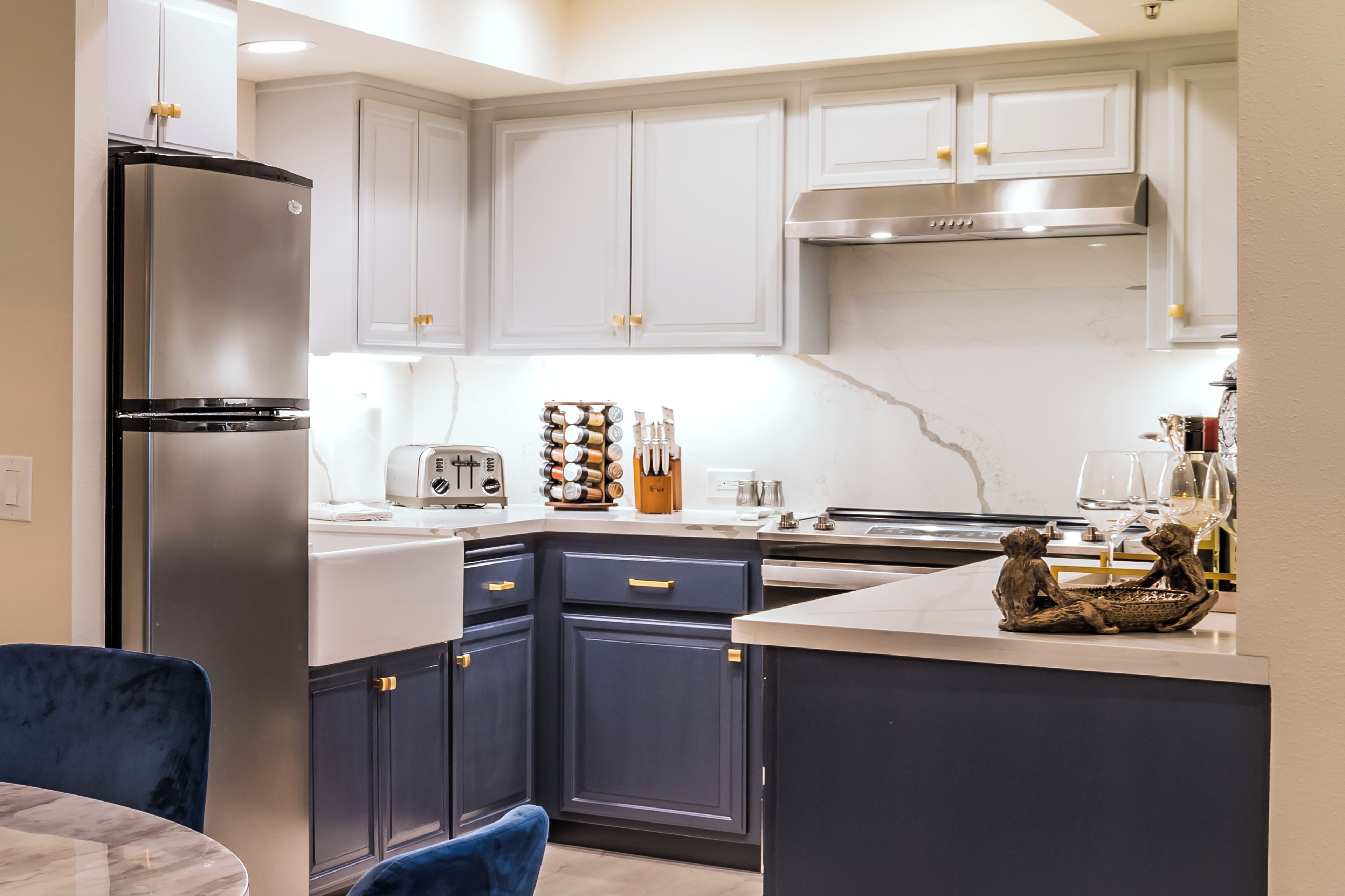 Una cocina moderna con armarios oscuros, un refrigerador de acero inoxidable y una isla central con una escultura decorativa.