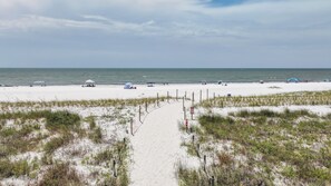A sandy beach with a clear path leading to the water, surrounded by dunes and a few beach umbrellas. - Brand New Listing, Beach, Pool, 2 K Beds (Mexico Beach)