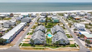 A coastal residential area with modern houses, a swimming pool, and a beach in the background. - Brand New Listing, Beach, Pool, 2 K Beds (Mexico Beach)