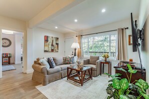 A living room with a sofa, armchairs, a coffee table, and a TV mounted on the wall. - Beautiful 1-Bedroom Unit - Quiet Neighborhood & Close Access to Vibrant Downtown (San Rafael)