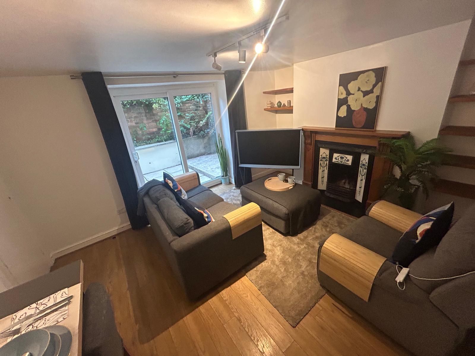 A living room with a sofa, a television, and a fireplace.