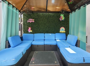A blue sectional sofa with a green artificial grass wall behind it, featuring neon signs. - 🦩The Flamingo Casita🦩🌴Tropical Vibes & Cozy Nights 🌴 (Hiaelah)