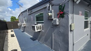 En bygning med udvendige ventilationsenheder, et overvågningskamera og et skilt med teksten 'Pas på flamingoer'.