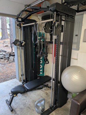 A gym with a bench, weight plates, and exercise equipment. - Dog friendly 3bd near Sunriver w/ large deck, chef's kitchen, and waterfront (Bend)