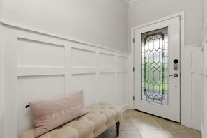 A white door with a glass panel and a lock, a bench with a cushion, and a textured wall with paneling. - ⚓Waterview-Resort Style Amenities-Bikes & More⚓ (Bradenton)