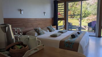 Quarto de hotel com uma cama, uma mesa com chaleira e vista para o exterior.
