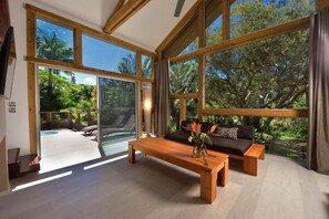 Una habitación amplia con ventanas grandes, un banco de madera y un sofá.