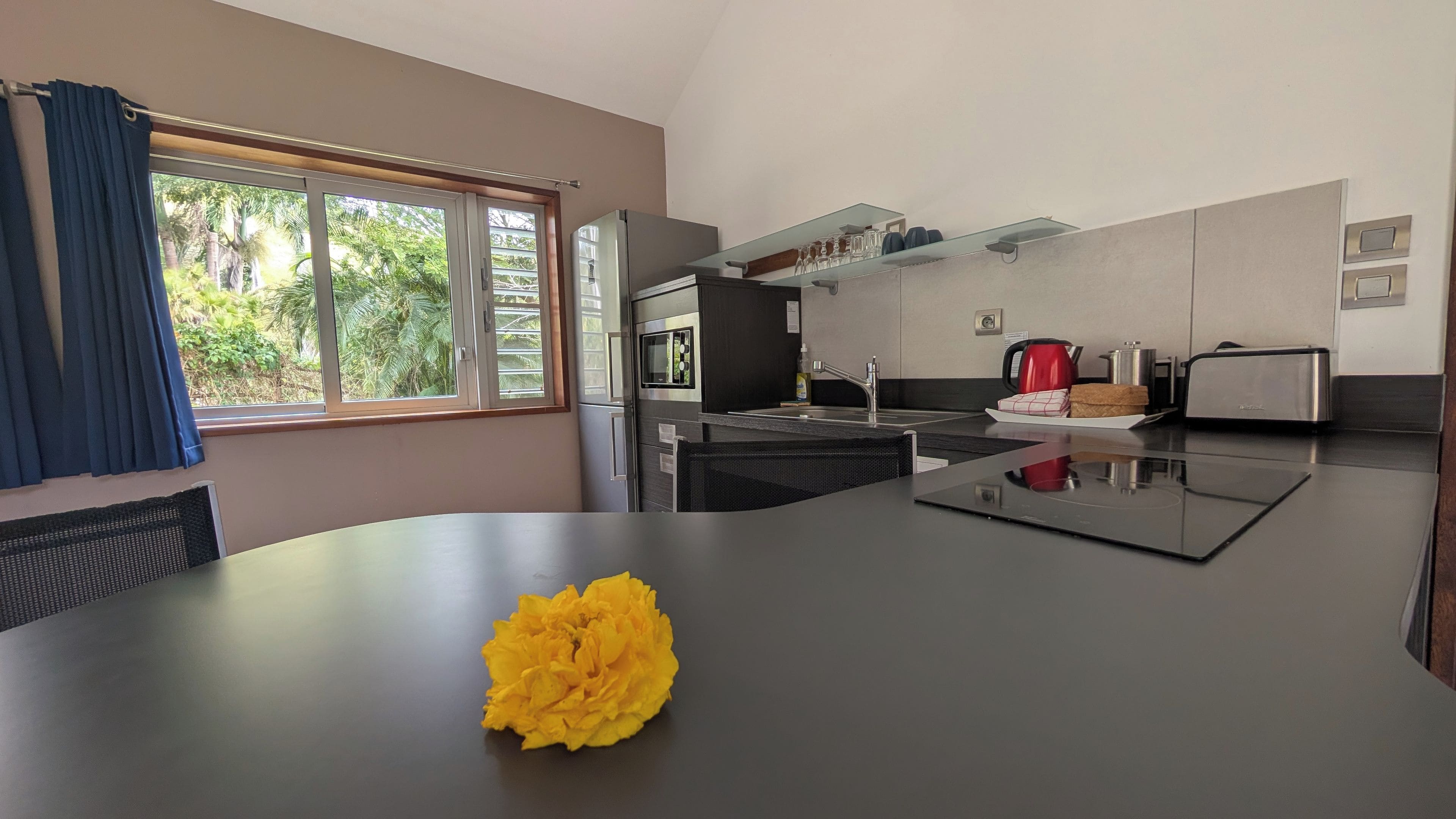 Cozinha moderna com ilha central, micro-ondas e torradeira.