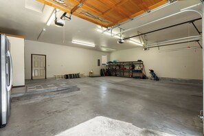 Eine geräumige Garage mit Betonboden, einer Tür zu einem weiteren Raum und einem Regalschrank an der Wand.
