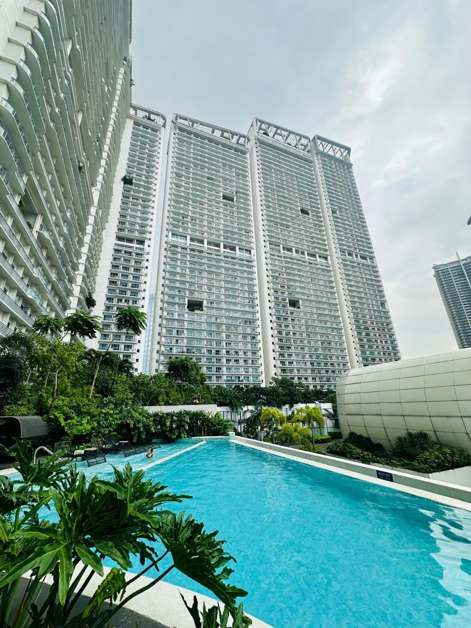 A high-rise building with a swimming pool in the foreground.