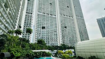 A high-rise building with a swimming pool in the foreground.