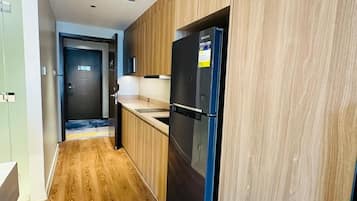 A modern kitchen with wooden cabinetry and a black refrigerator.