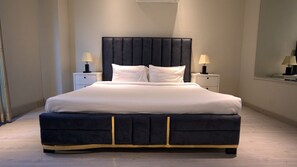 Un dormitorio moderno con una cama grande, dos mesitas de noche y un cabecero.